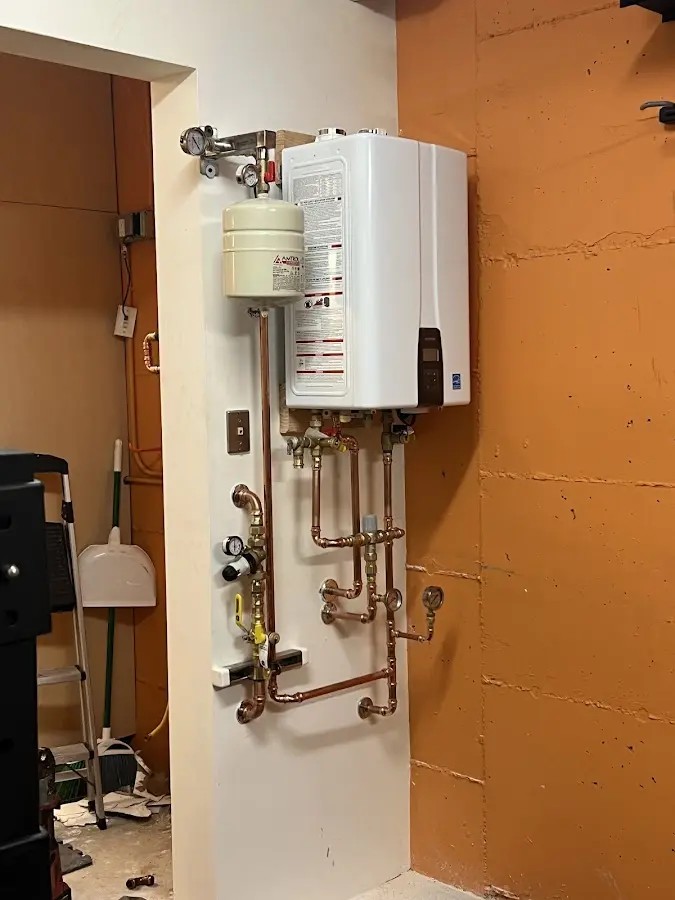 Plumbing technician inspecting water heater connections in Berlin
